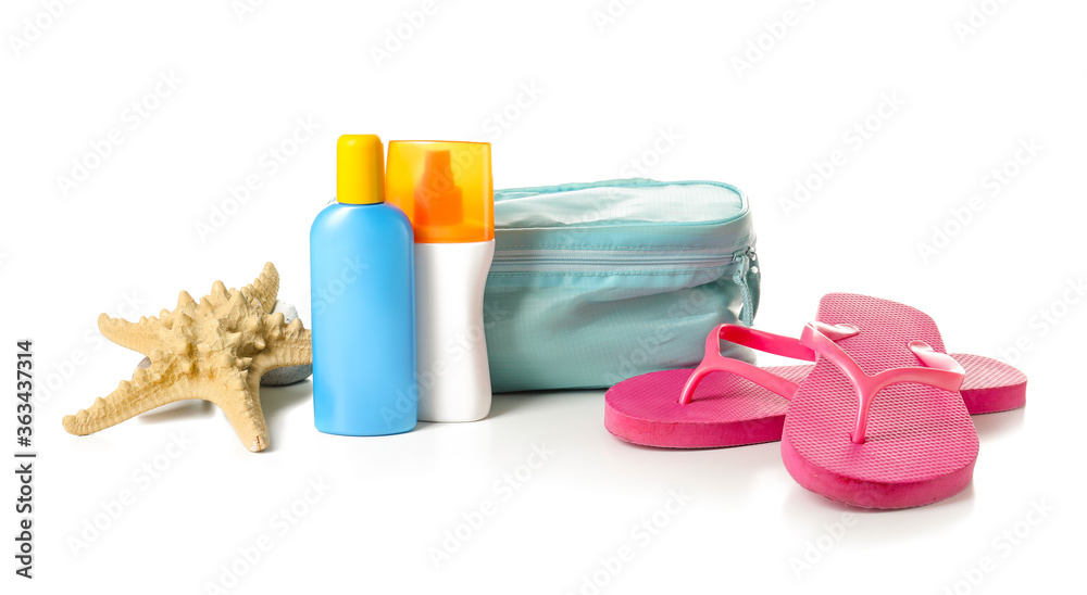 Bag with sunscreen cream and flip-flops on white background