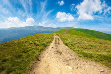Mountain Road Through Grassy Meadow. Wonderful Summer Adventure. Clouds On The Blue Sky