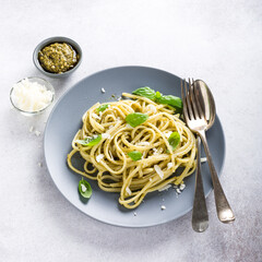 Wall Mural - Homemade pasta, spaghetti, linguine with green pesto and basil. Italian healthy food concept with copy space, top view.