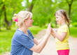 © Ermolaev Alexandr - Little girl with syndrome down plays with her mother in a summer park