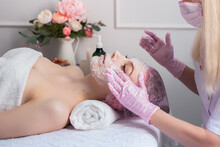 Young Beautiful Girl At The Cosmetologists Office. Cosmetic Procedure, Spa, Rejuvenation, Health. Hands In Pink Gloves