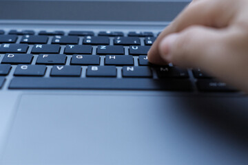 woman is typing on laptop keyboard, selective focus, working in evening at laptop of his house, hands closeup, concept of remote work, quarantine, downshifting