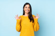 © luismolinero - Young caucasian woman isolated on blue background showing ok sign with two hands