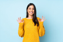 Young Caucasian Woman Isolated On Blue Background Showing Ok Sign With Two Hands