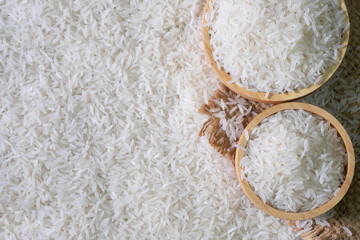 Wall Mural - White rice seed in Brown wooden bowl on Rice background.