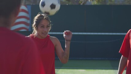 Wall Mural - Player heading ball as female soccer team warm up during training before match - shot in slow motion