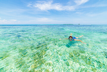 Wall Mural - Woman snorkeling in caribbean on coral reef tropical turquoise blue water. Indonesia Wakatobi archipelago, marine national park, tourist diving travel destination