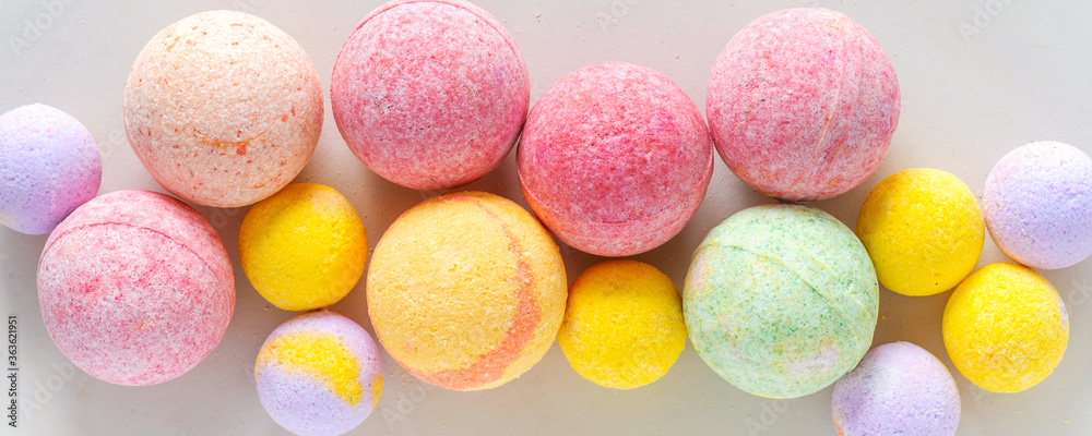 Multicolored bath bombs on a gray background top view, banner - obrazy, fototapety, plakaty 