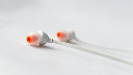 Wall Mural - Selective focus shot of an earphone placed on a white background