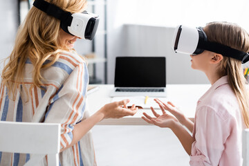 Wall Mural - Smiling woman using vr headsets with daughter at home