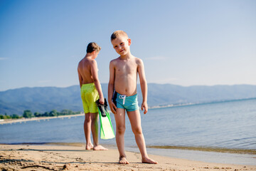 Two boys standing on a sea shore