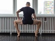 © Javier Pardina/Stocksy - Young man training ballet at school.