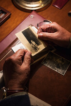 Top View Of An Elderly Man At The Desk Looking At Old Photographs