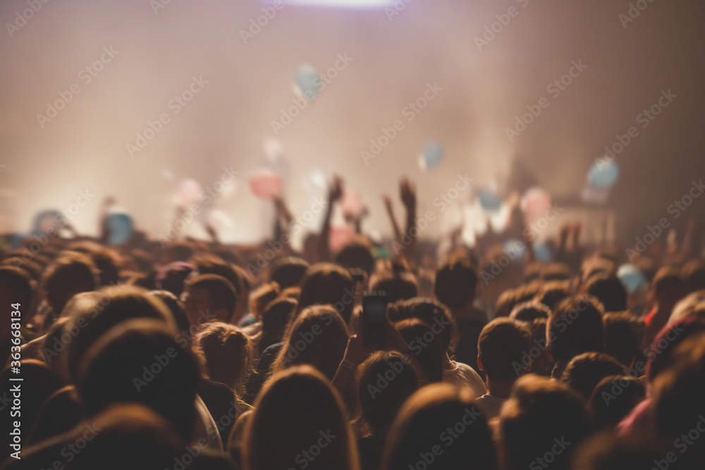 A crowded concert hall with scene stage lights, rock show performance, with people silhouette
 - obrazy, fototapety, plakaty 