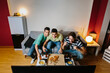 © MyMicrostock/Stocksy - Friends watching a soccer match at home