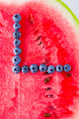 Wall Mural - Watermelon and blueberries on white background. Half of watermelon on wooden boards. Berries for vegan. Clock hands of berries. Watch from food