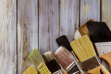 Various paint tools brush on white wooden table background