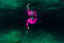 An Adventurous Young Lady Snorkeling In The Ocean At Night