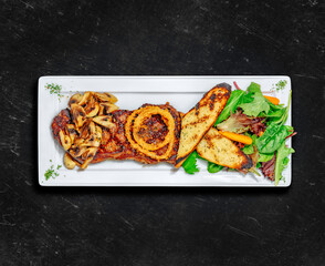 New York Striploin Steak. Healthy food. Grilled steak served with two sides, garlic toast, mushrooms and tossed salad. Chalked background. Top view