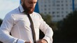 © stanis88 - Businessman in white shirt tying the necktie outdoors
