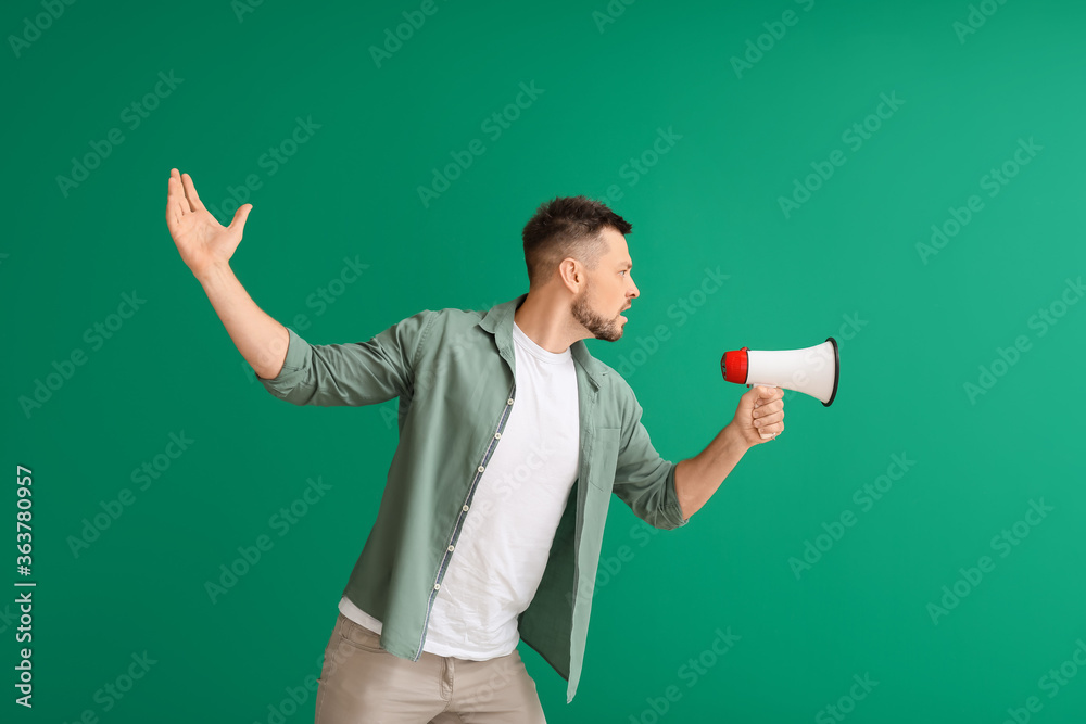 Protesting man with megaphone on color background