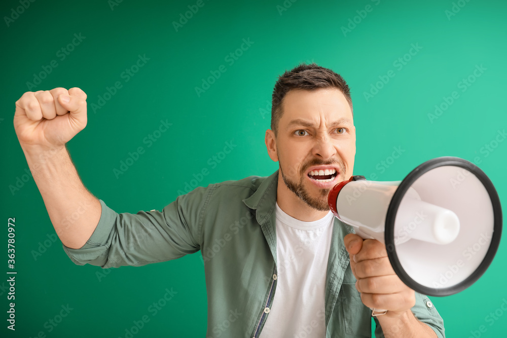 Protesting man with megaphone on color background