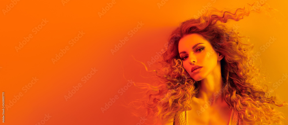 High Fashion. Woman in colorful neon gold light, make-up. Sexy blond girl, stylish curly hair, trendy makeup. Golden neon portrait. Creative beauty, fashionable model face, voluminous hairstyle - obrazy, fototapety, plakaty 
