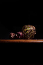 Close-up Of Artichokes On Table Against Black Background