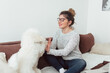 © likoper - Young woman enjoying with her dogs. Young woman siting on sofa and enjoying with her pets.