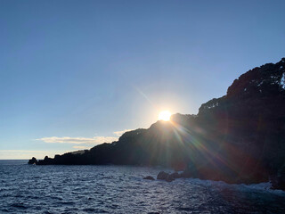 sunset over the sea with mountain in background