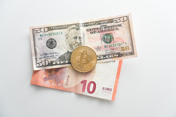 Biktcoin coin lies on paper euro and dollar banknotes. Concept of virtual currency in exchange