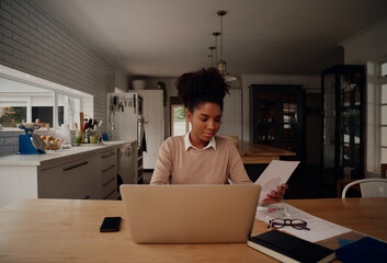 Wall Mural - Serious focused businesswoman typing on laptop holding papers preparing report analysing work results