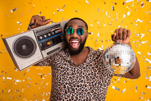 Close-up Portrait Of His He Nice Handsome Bearded Cheerful Cheery Cool Emotional Guy Holding In Hands Shine Disco Ball Carrying Player Isolated On Bright Vivid Shine Vibrant Yellow Color Background