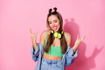 Canvas Print - Photo of millennial lady showing finger horns sticking tongue out mouth listen earphones wear denim jacket green crop top naked belly isolated pastel pink color background