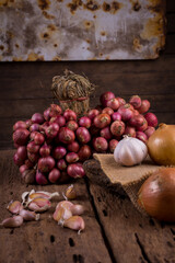 Red and bulb onions with whole organic garlic on wooden table