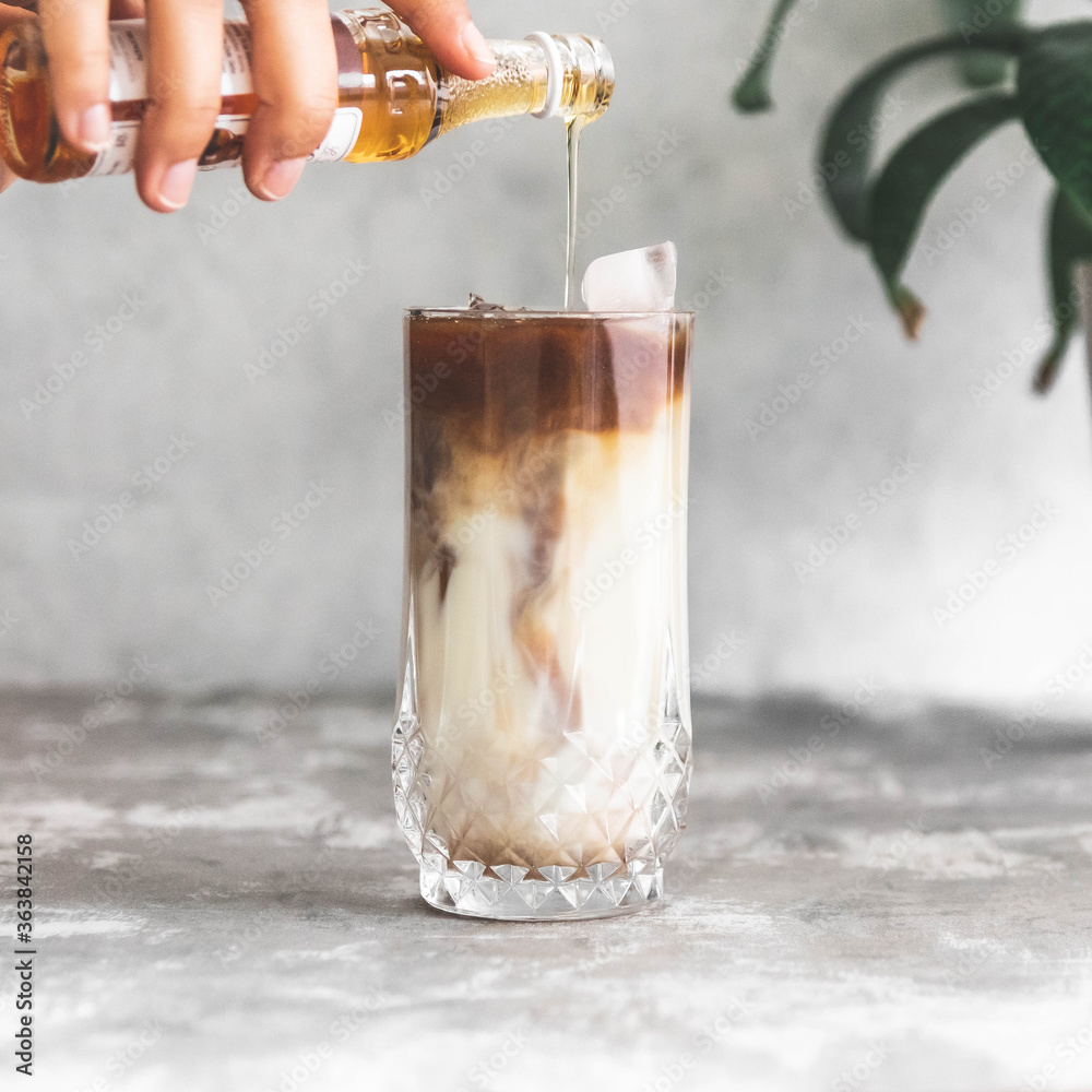Midsection Of Person Pouring Syrup Into Coffee In Glass - obrazy, fototapety, plakaty 