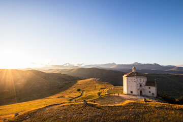 Mountain ancient ruins at sunset. Medieval Rocca Calascio church with foggy landscape in background. Relax in mountain with hills and forest at dusk, hiking and trekking tourism