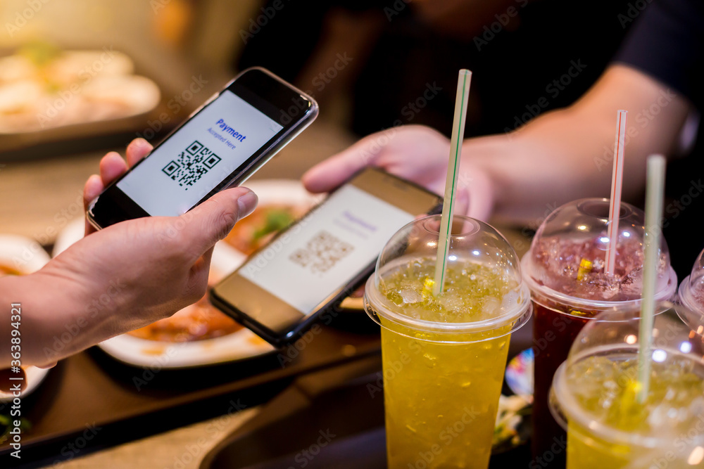 Selective focus to smart phone in hand to scan QR code tag with blurry ...