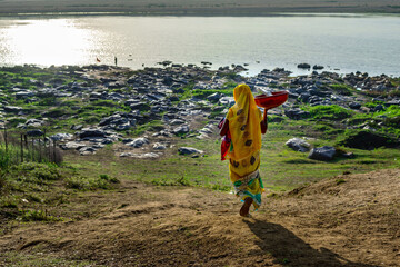 Wall Mural - A woman goes to bath in the Narmada river at Bandrabhan, Madhya Pradesh, India.