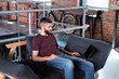 © LIGHTFIELD STUDIOS - handsome businessman sitting on sofa and using laptop with blank screen in office
