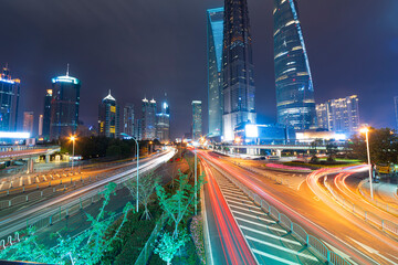 High-rise buildings, overpasses, and heavy vehicular traffic in the city center at night.