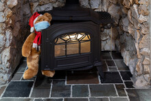 Santa Teddy Bear Coming Out From A Wood Burning Stove With A Face Mask On