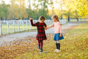 two little girls in autumn park