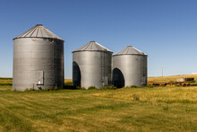 Grain Storage Silos In The Afternoon Sun At A Farm In The Rolling Hills Near Mandan, North Dakota