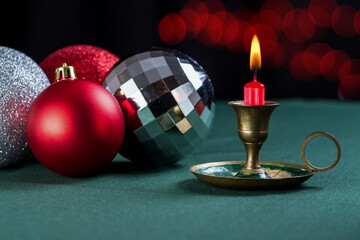 Decorative Christmas candle accompanied by tree balls and Christmas bokeh