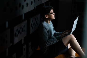 Young Asian man freelancer working and connect to internet on laptop computer for conference call to customer at home