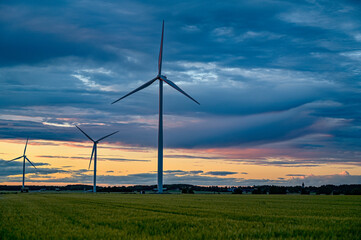  big windmills on field with dramatic sky