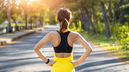 Wall Mural - Back view of young fitness woman running on the road in the morning, People and sport concept
