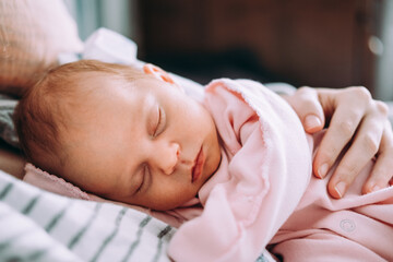 cute newborn baby sleeping with mother. happy family concept.