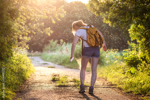 Photographie Woman applying insect repellent against mosquito and tick on her leg during hike in nature